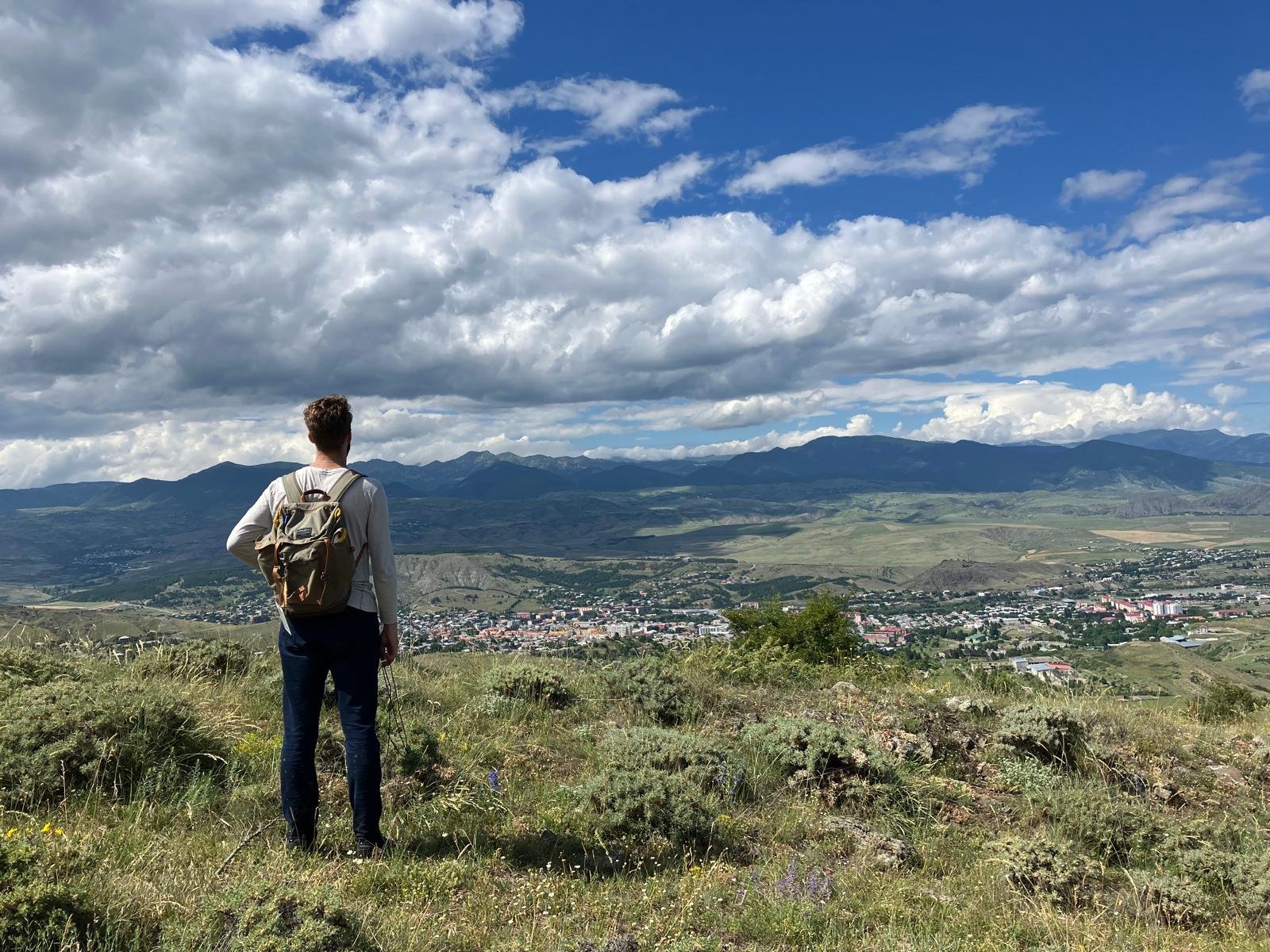 A hiker overlooking Akhaltsikhe and the surrounding mountains in Georgia.