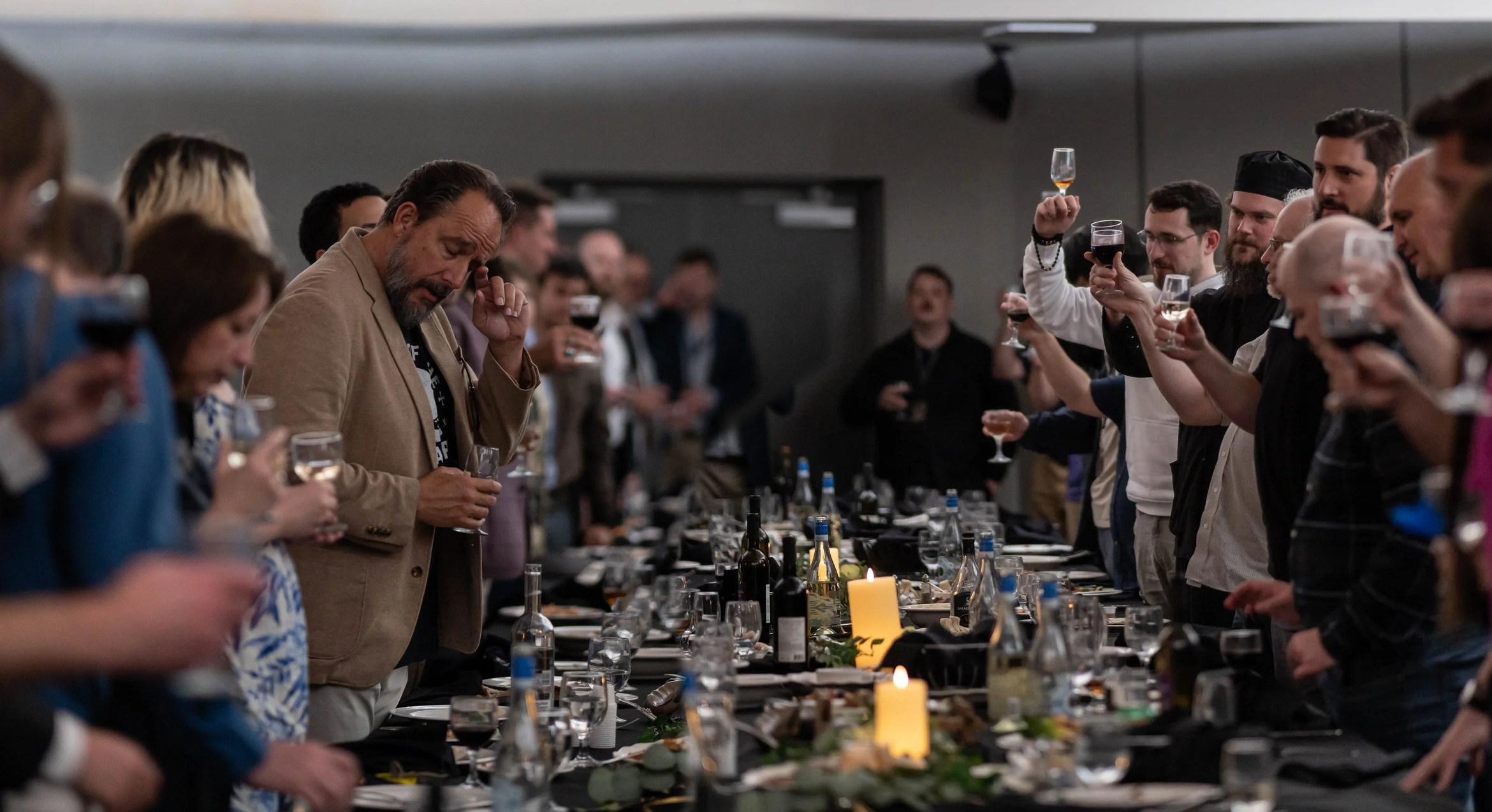 People raising glasses around a table of shared food.